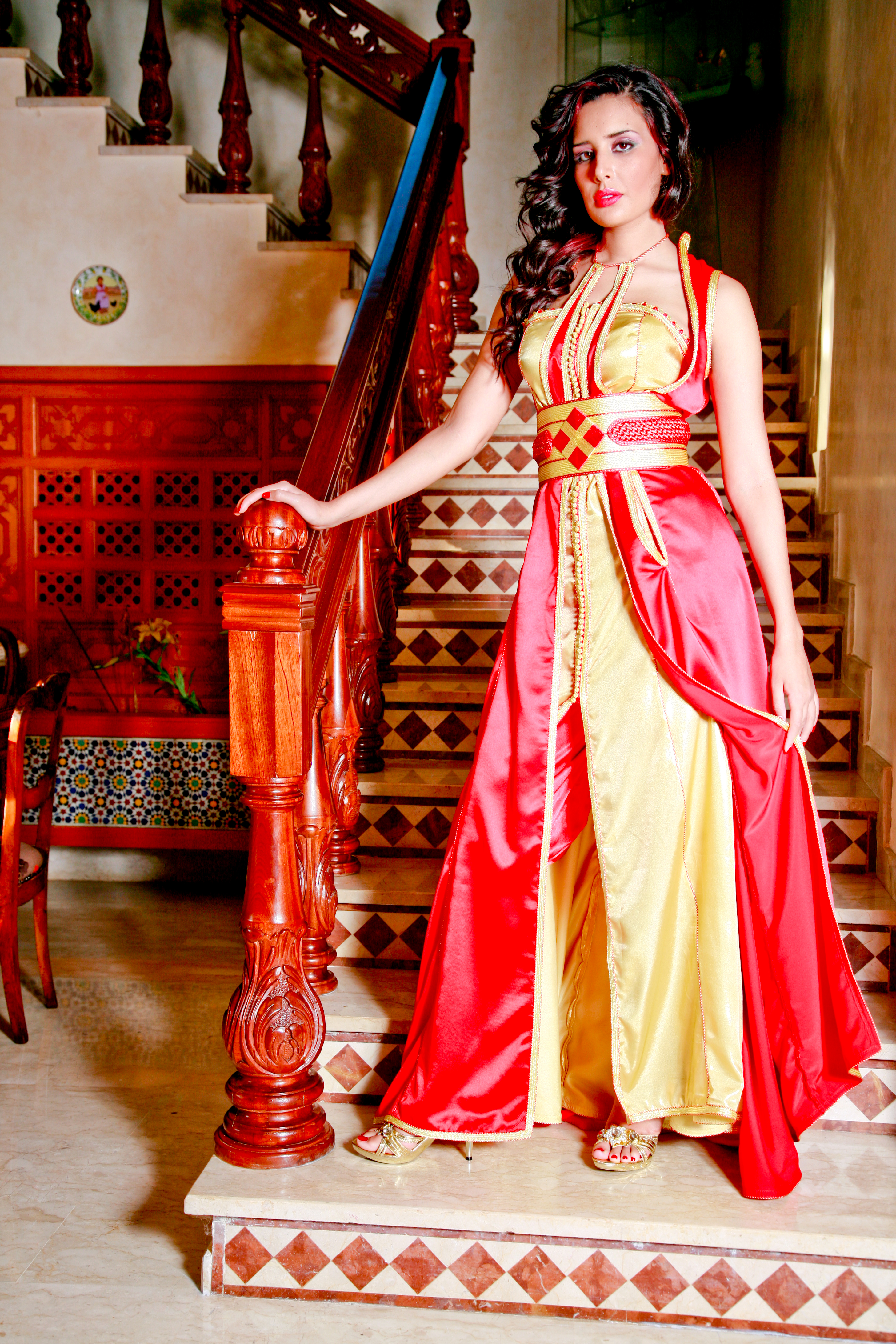 Takchita rouge corail et jaune doré — devant un escalier de zellige